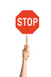 Hand holding stop sign on blank background