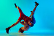 Young male athletes, training wrestling with intensity and focus, aiming to overcome opponent on blue background in neon. Concept of combat sport, martial arts, competition, tournament, athleticism