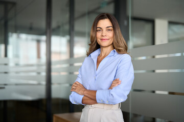 Wall Mural - Confident smiling middle aged business woman attorney, 45 years old lady entrepreneur, mature female professional executive manager leader standing arms crossed in office looking at camera. Portrait.