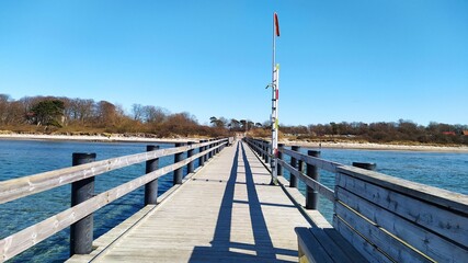 Wall Mural - Wooden pier in the sea on the beach near the shore