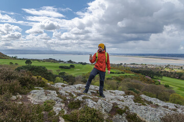 Happy male hiker in the mountains with mobile phone