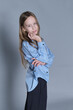 Self-assured girl in a blue shirt looks over shoulder. Perfect for themes around growing up and becoming independent.