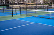 © Mat Hayward - Empty pickleball court outside. The ground is blue and the net is mounted.