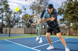 © Mat Hayward - Co-ed pickleball team. The players are active on the court for a fun and fast game.