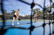 © Mat Hayward - Two female pickleball players work together as a team during a game on an outdoor court.