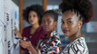© Nemanja - Team or group of three multiethnic and diverse businesswomen standing in office near the whiteboard. Female employees information presentation, drawing or writing with marker, planning strategy