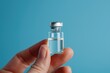 A hand holding a small glass vial filled with water. Suitable for science or medical concepts