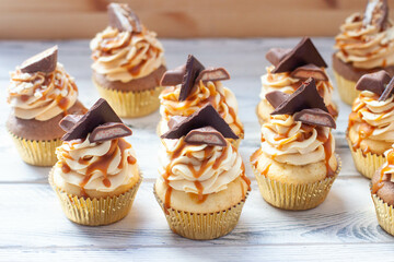 Wall Mural - Homemade butterscotch cupcakes with caramel syrup and cream cheese frosting