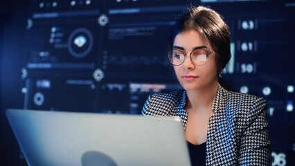 Beautiful Indian woman with eyeglasses working with computer in office of modern digital company