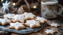 A Closeup Photo Of White Star-shaped Cookies With Glaze, Arranged On An Isolated Slate Platter And Placed Next To A Vintage Coffee Mug In The Background.