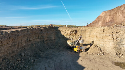 Poster - Excavator on earthmoving, aerial view. Open pit mining. Backhoe dig ground in quarry. Excavator load dolomite in haul truck, mining ore, drone view. Heavy machinery  on extracts rock or mineral.