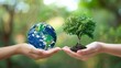 Concept image for World Environment Day: Two human hands holding a globe of the earth and a heart-shaped tree against a blurry green background. 