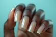 Elegant beige manicure on long coffin nails against a teal background