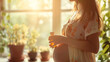 Young pregnant woman holding a bottle of aromatherapy essential oil or herbal tincture in a bright cozy home