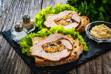Wall Mural - Sandwich with roast turkey breast and greens on wooden table

