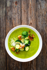 Wall Mural - Cream zucchini soup with croutons, Parmesan cheese and fresh dill on wooden table
