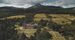 Scotland landscape aerial shot: mountains, ancient Brodick Castle with Goatfell mount. Epic scenery of Scottish landmarks. Wonderful forests and valleys at summer day wide view