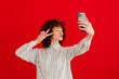 © Tania Cervian/Stocksy - Cheerful woman taking photo of self with smartphone