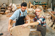 © chokniti - Diligently skilled man work with wood in carpenter's shop, using tools and equipment to transform timber planks into bespoke wooden pieces, craftsmen workshop with natural material, furniture industry