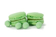 closeup of green macaroon or meringue cookies and green mini Easter eggs on a white background