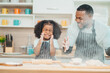 © chokniti - In a home kitchen, black father and his daughter bond over cooking a meal food, their laughter and love filling the air, embodying the joy of African American family life, Father's Day concept