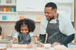 © chokniti - In a home kitchen, black father and his daughter bond over cooking a meal food, their laughter and love filling the air, embodying the joy of African American family life, Father's Day concept