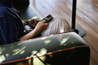 © Jeremiah Le/Stocksy - Asian man checking his mobile phone in relaxing space
