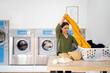 © Santi Nuñez/Stocksy - Woman doing laundry in the laundromat shop