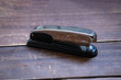 Shiny metal stapler  (typical) on wooden surface 