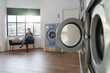 © Santi Nuñez/Stocksy - Woman waiting to wash her clothes in a laundromat