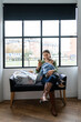 © Santi Nuñez/Stocksy - mother and son waiting to wash their clothes in a laundromat