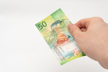 Man holding 50 CHF Swiss franc banknote paper currency isolated on white background