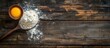 Background with space for text - egg yolk in an old-fashioned spoon and flour in an old-fashioned cup on a wooden surface. View from above.