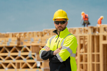 Wall Mural - Portrait confident foreman in hard hat at new house under construction. Builder on construction site. Manufactured Home News, modular home, conventional housing. Builder front of american house.