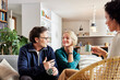 © ALTO IMAGES/Stocksy - Couple talking during visit financial advisor at home