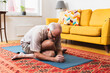 © Diego Martin/Stocksy - Aged man doing exercises at home