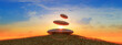 Zen Stones in Balance Against Sunset Sky on Grassy Hill
