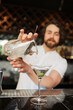 Bartender Pouring Martini with Precision in a Trendy Bar