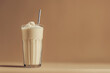 © Klay - vanilla protein shake in glass with whipped cream and metal straw on warm beige background, copy space for text