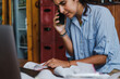 © Luis Herrera/Stocksy - frustrated businesswoman with a messy  workspace with many receipts