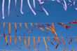© Shava Cueva/Stocksy - Paper strips hanging with blue sky background