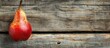 Red pear placed on a wooden background with space for text.