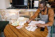 © Oleksii Syrotkin/Stocksy - Barista checking data