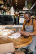 © Oleksii Syrotkin/Stocksy - Barista controlling earnings