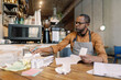 © Oleksii Syrotkin/Stocksy - Barista doing financial tracking