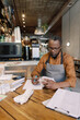 © Oleksii Syrotkin/Stocksy - Waiter focusing on financial matters