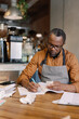 © Oleksii Syrotkin/Stocksy - Barista keeping records of expenses