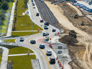 Canvas Print - Industrial construction roadworks at roundabout intersection with moving cars in Venice, Florida. Development of urban circular transportation crossroads