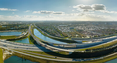 Wall Mural - View from above of USA transportation infrastructure. Aerial view of american freeway intersection with fast driving cars and trucks in Miami, Florida