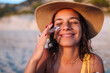 © Brat Co/Stocksy - A Smiling Woman On the Beach Applying Sunscreen
